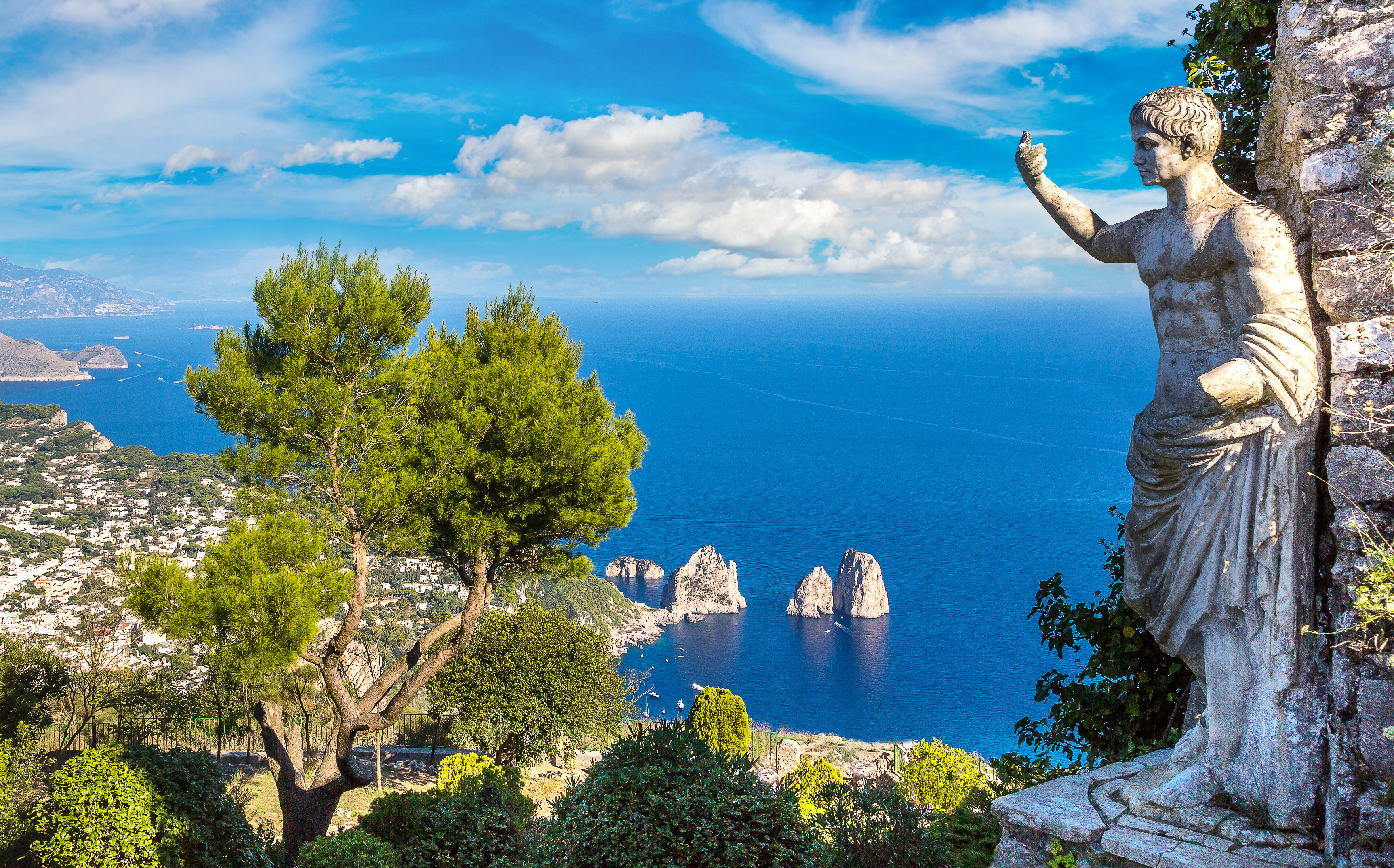 Smuk panoramaudsigt over Capri ø med antik romersk statue og de berømte Faraglioni klipper i det turkisblå Middelhav