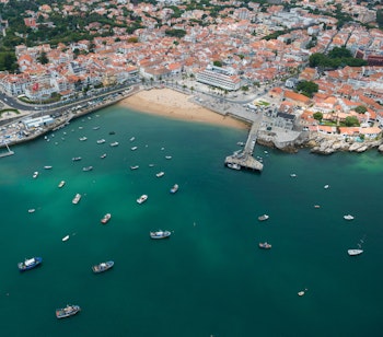 Betagende luftfoto af Cascais kystby nær Lissabon i Portugal med smuk strand, turkisblåt hav og charmerende bylandskab