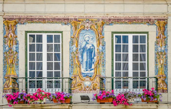 Charmerende gade i Cascais, Portugal med traditionel arkitektur, farverige flag og smukke vinduespartier i den historiske bymidte