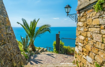 Malerisk udsigt over Castellabates azurblå kystlinje med traditionelle bygninger på skrænten i Cilento, det hemmelige syditalienske paradis