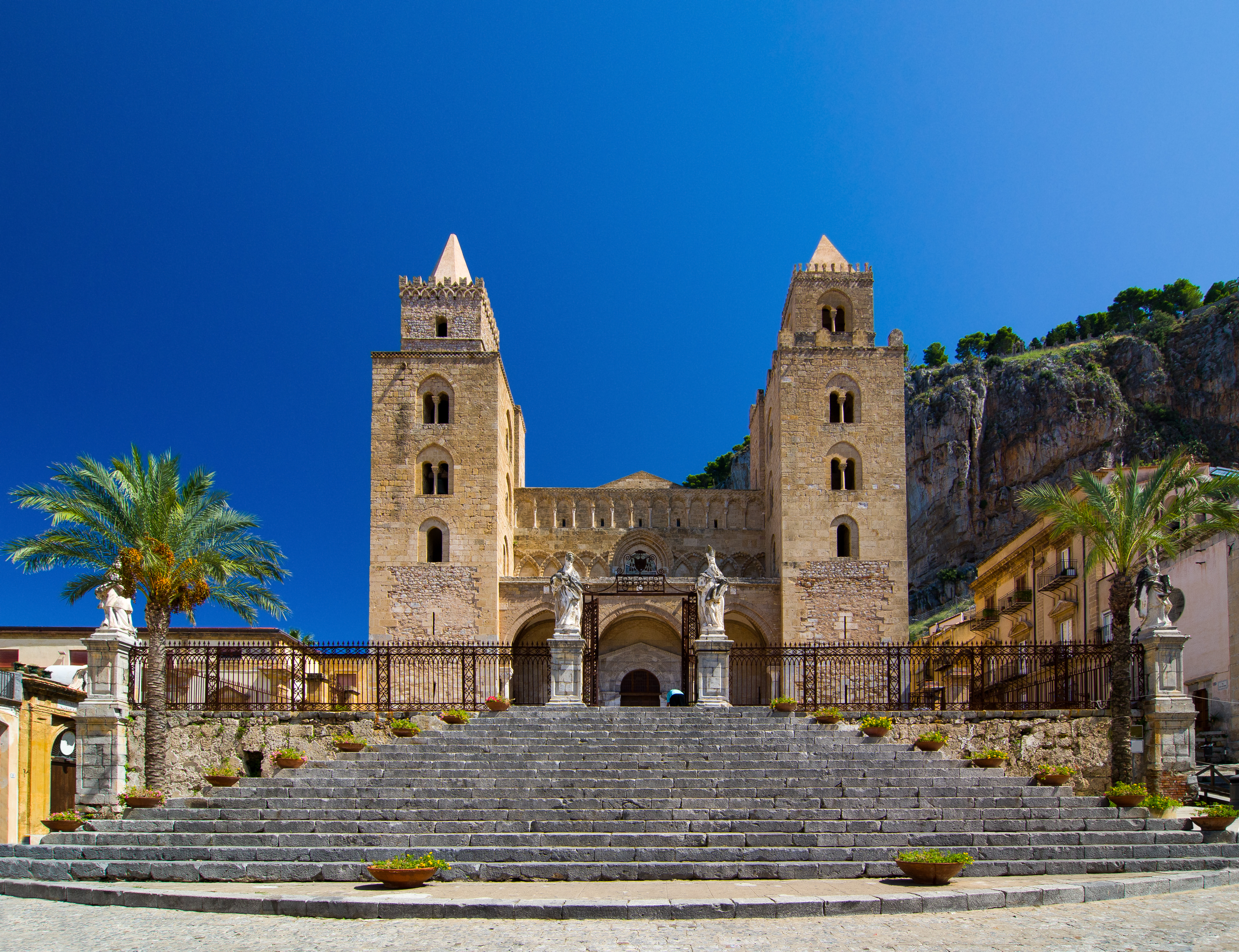 Historisk normannisk domkirke i Cefalù med tvillingetårne og stentrappe på Sicilien