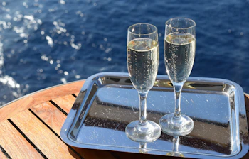 To champagne glas med mousserende vin på krydstogtskib med havudsigt