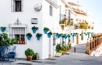 Idyllisk hvid gade i Mijas med farverige blomsterkrukker på væggene i Andalusien, Costa del Sol, Sydspanien