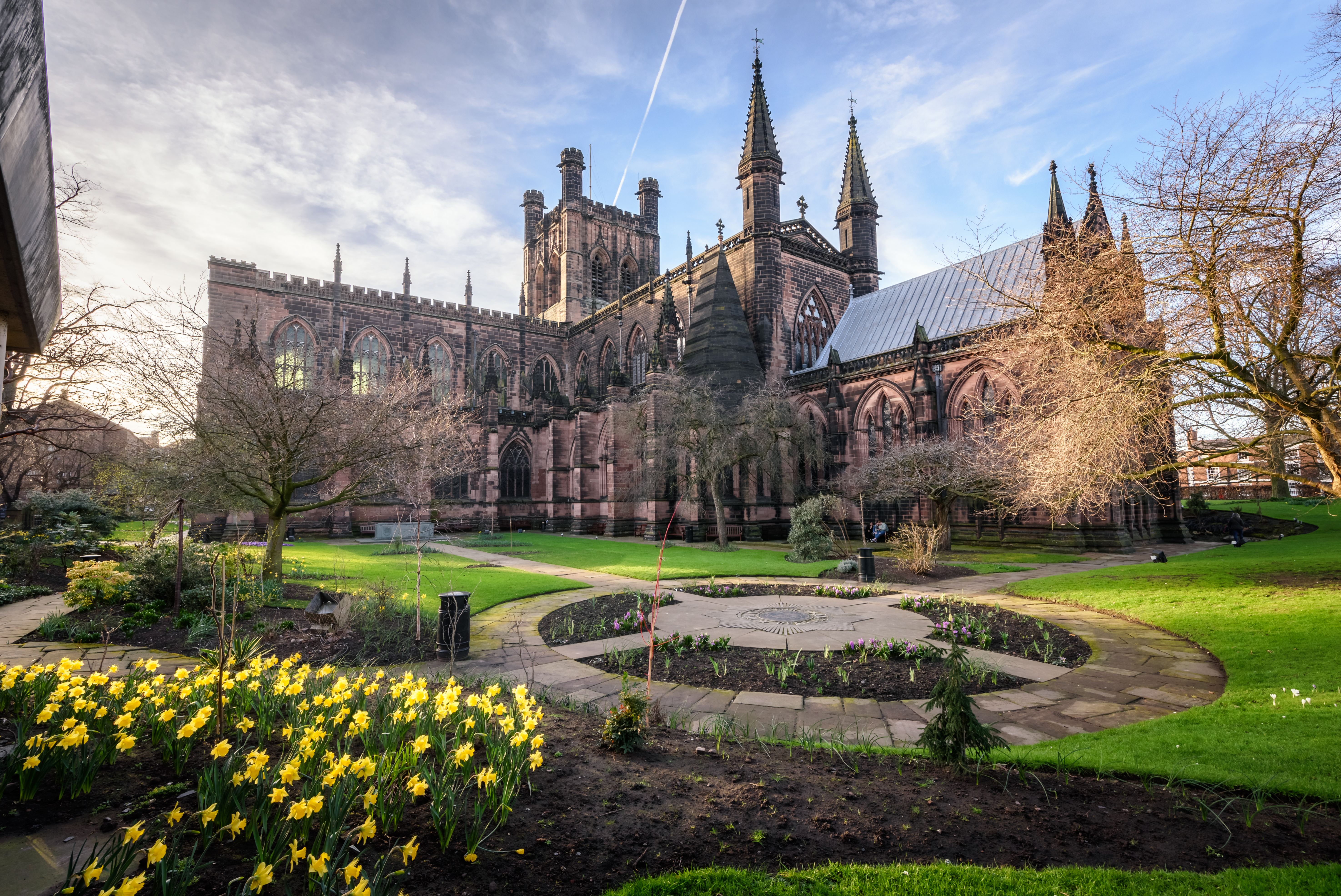 Historiske Chester Katedral med blomstrende gule påskeliljer i forårshaven, Chester, England