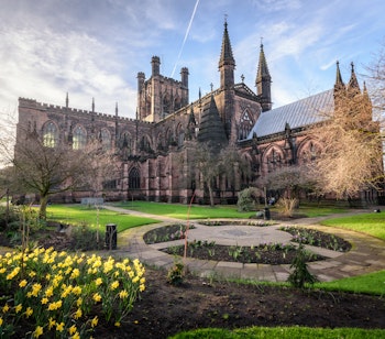 Historiske Chester Katedral med blomstrende gule påskeliljer i forårshaven, Chester, England