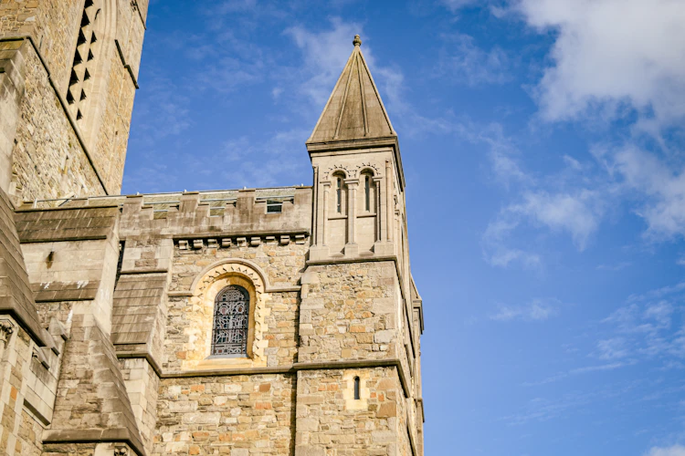Christ Church Cathedral i Dublin med middelalderligt stentårn og spir mod blå himmel, Irland