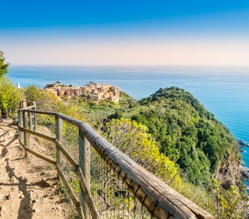 Panoramisk udsigt fra vandreruten ved Corniglia i Cinque Terre, Italien, med farverige bygninger på klippen over det azurblå Middelhav
