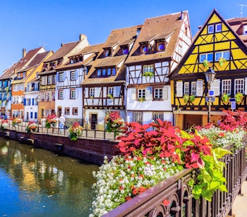 Farverige bindingsværkshuse langs kanal i Colmar Alsace med blomsterkasser
