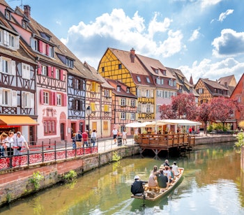 Malerisk udsigt over Lille Venedig i Colmar med farverige bindingsværkshuse langs kanalen, turistbåd på vandet og charmerende stemning i hjertet af Alsace