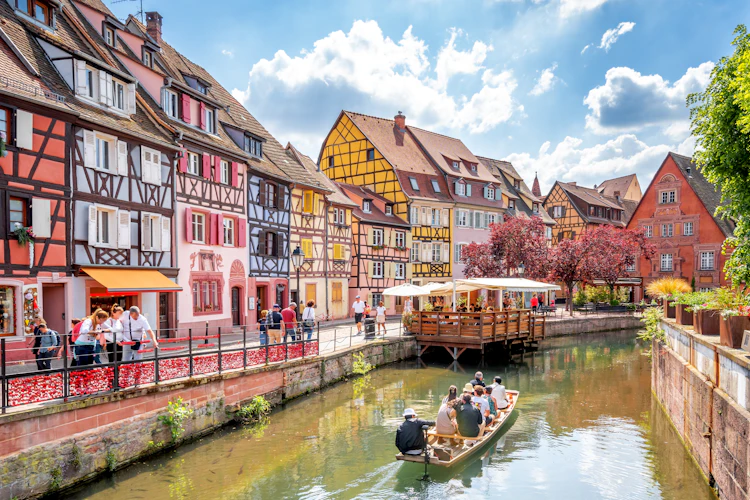 Malerisk udsigt over Lille Venedig i Colmar med farverige bindingsværkshuse langs kanalen, turistbåd på vandet og charmerende stemning i hjertet af Alsace