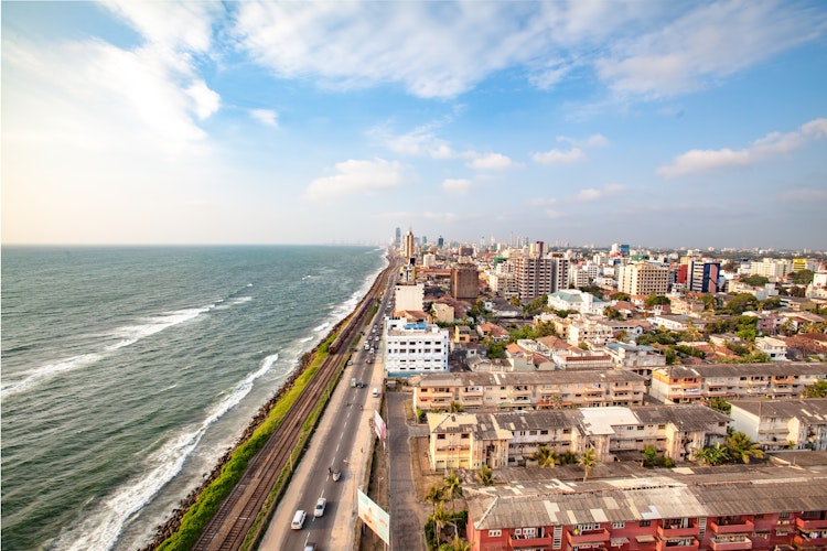 Panoramaudsigt over Colombo i Sri Lanka med skyskrabere langs kysten, blåt hav og bymiljø under skyfyldt himmel