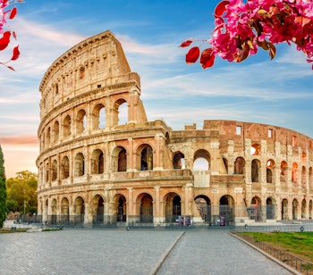 Det historiske Colosseum amfiteater med forårsblomster i forgrunden ved solopgang i Rom, Italien