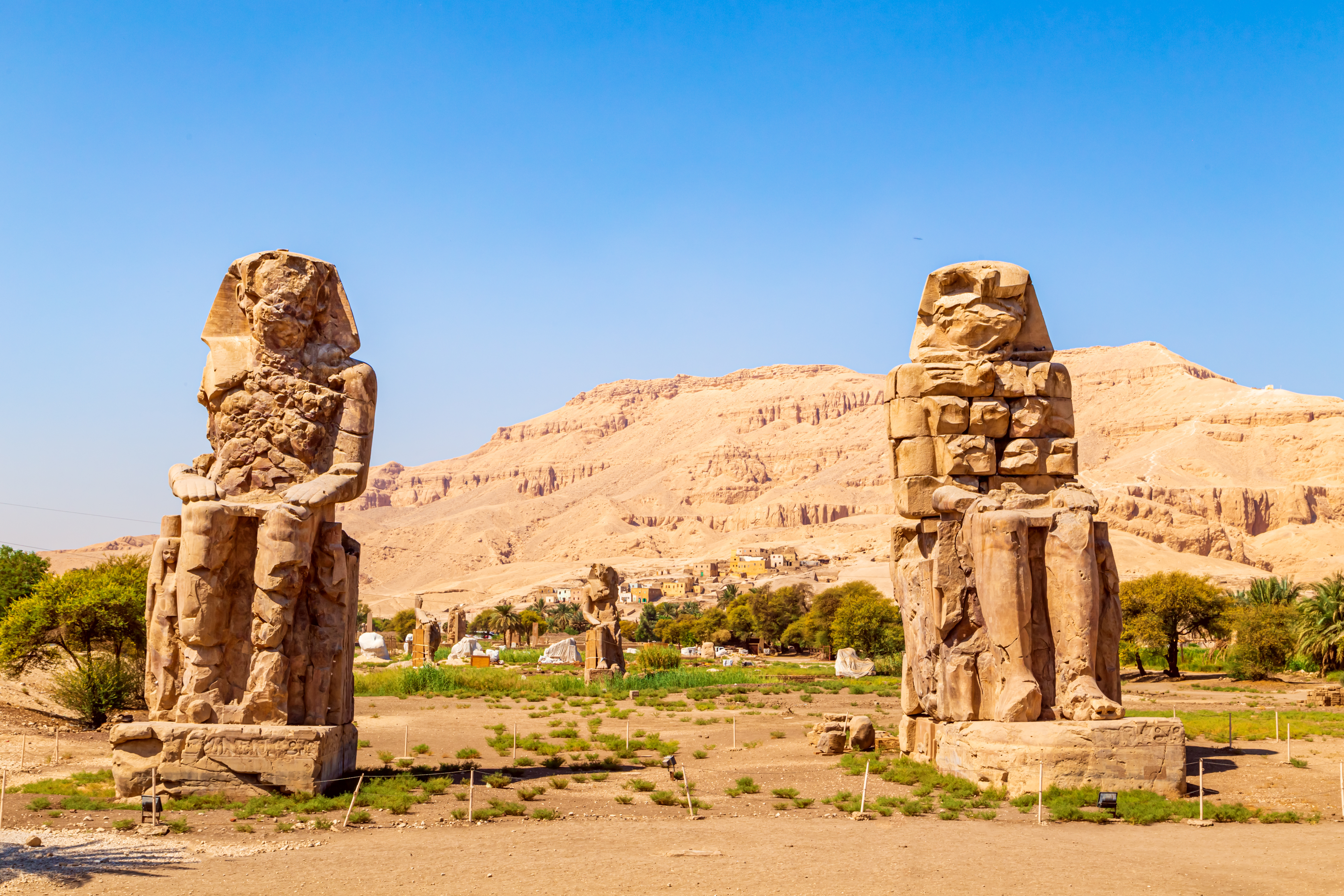 De massive Memnon-kolosserne forestiller farao Amenhotep III og står i ørkenen nær Luxor i Egypten