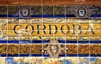Historisk keramisk flisekunst med Cordoba bynavn på dekorativ spansk væg i Andalusien