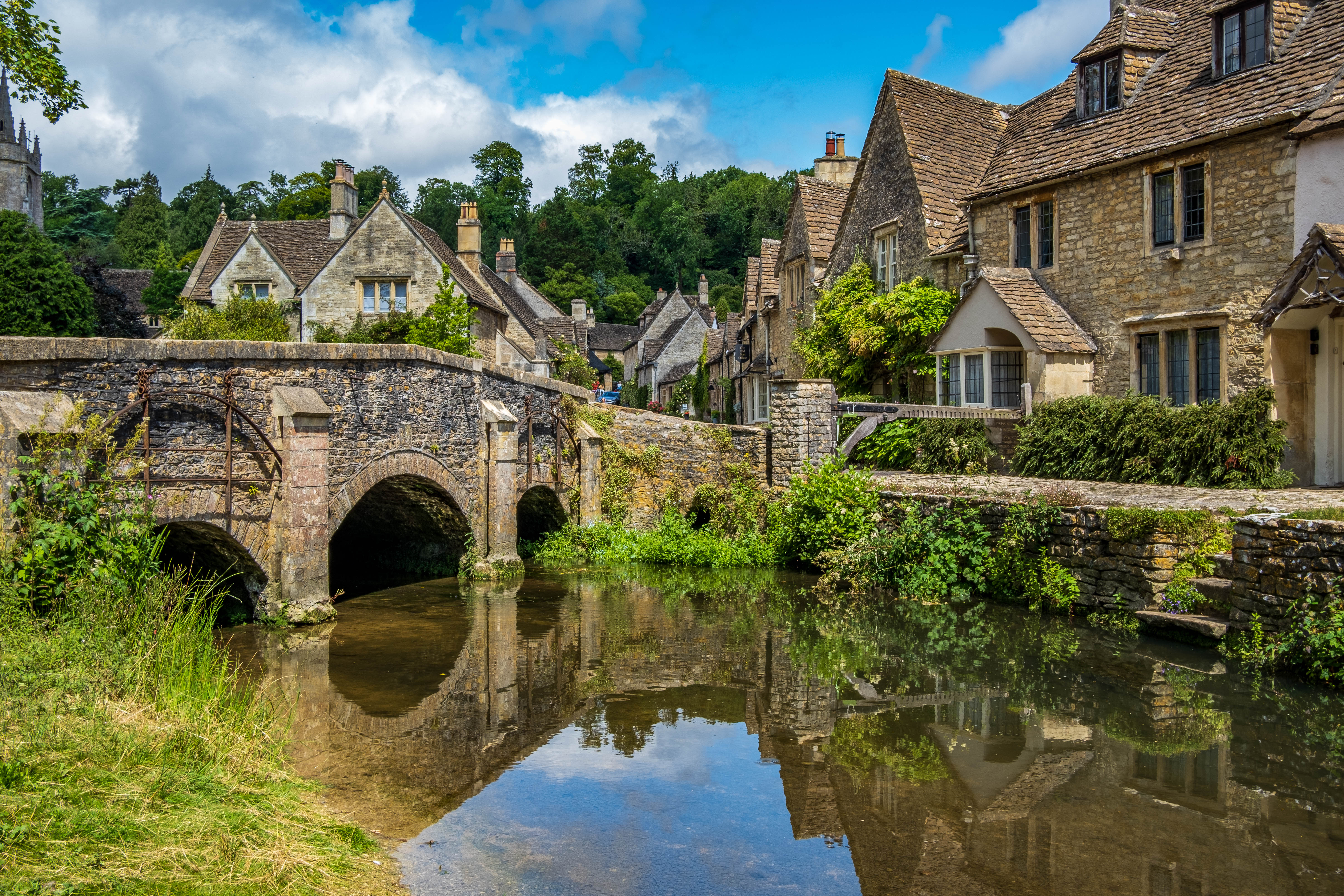 Historisk Cotswolds landsby med middelalderlig stenbro og traditionelle engelske huse ved floden