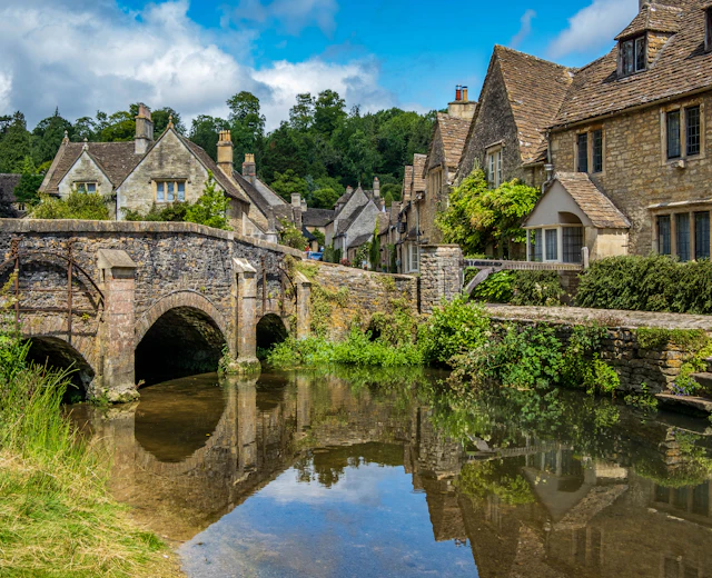 Historisk Cotswolds landsby med middelalderlig stenbro og traditionelle engelske huse ved floden