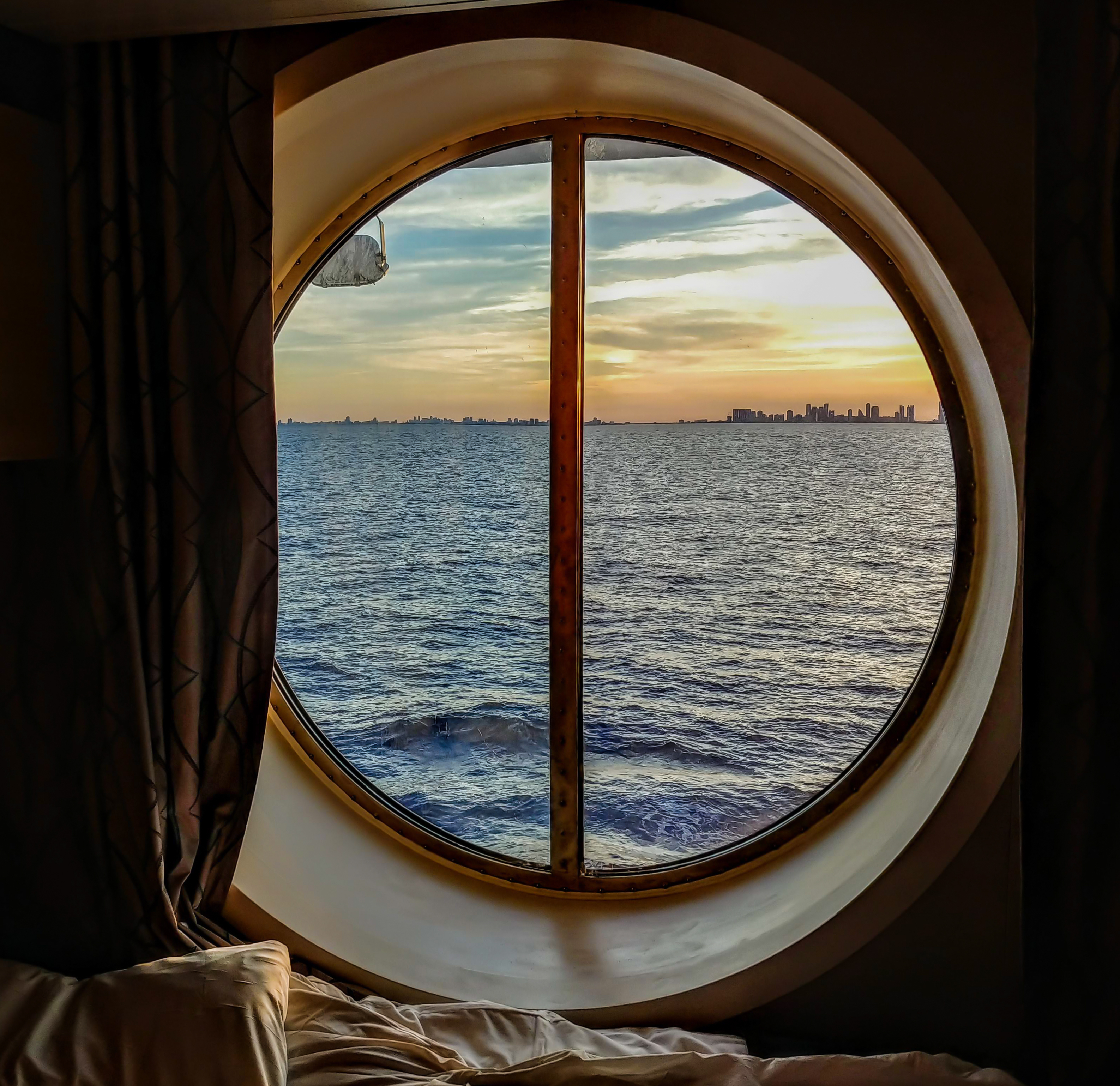 Luksus cruiseskib kahyt med rundt vindue og smuk solnedgang over havet