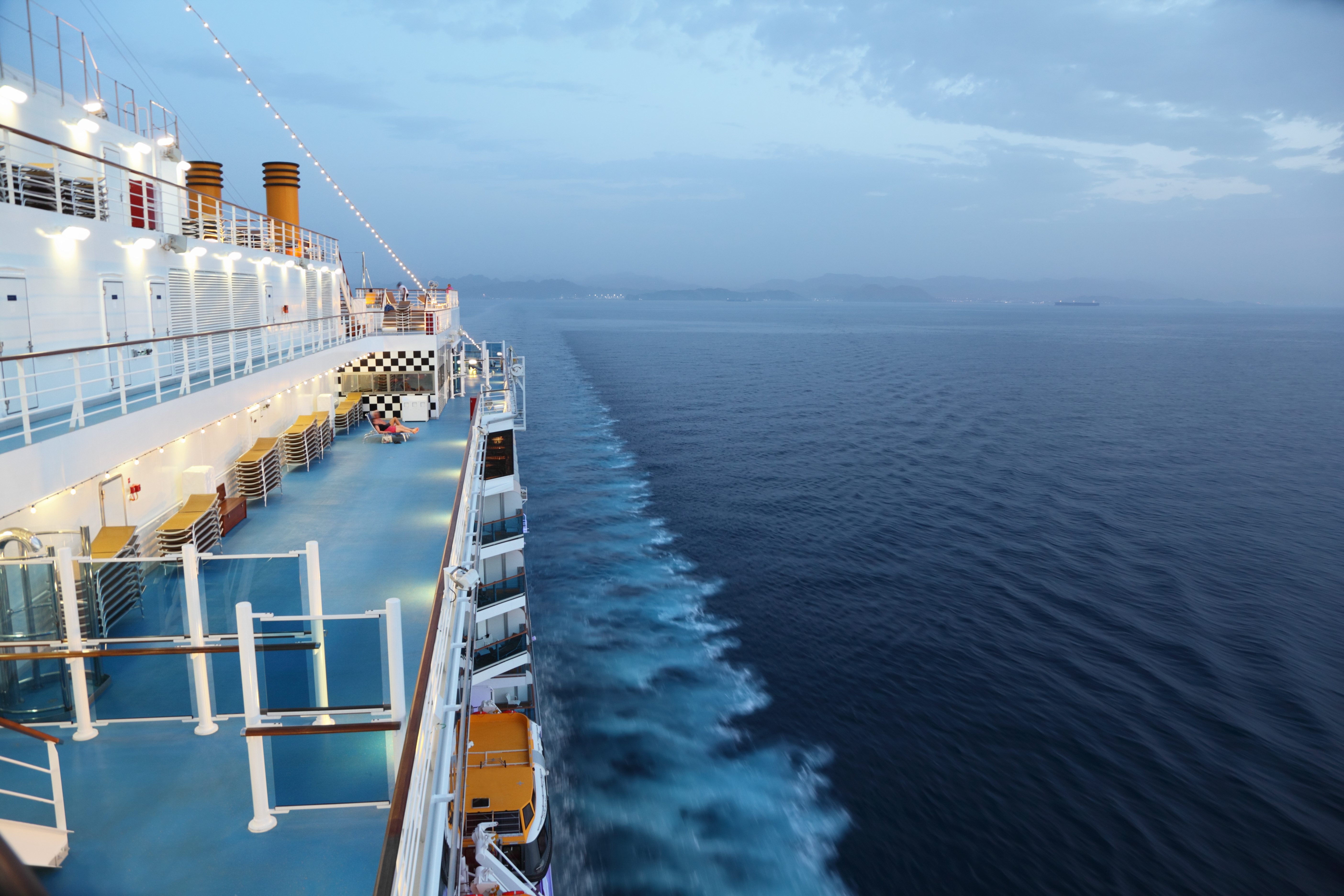 Cruise skib dæk om aftenen med havudsigt og passagerer på middelhavet rejse