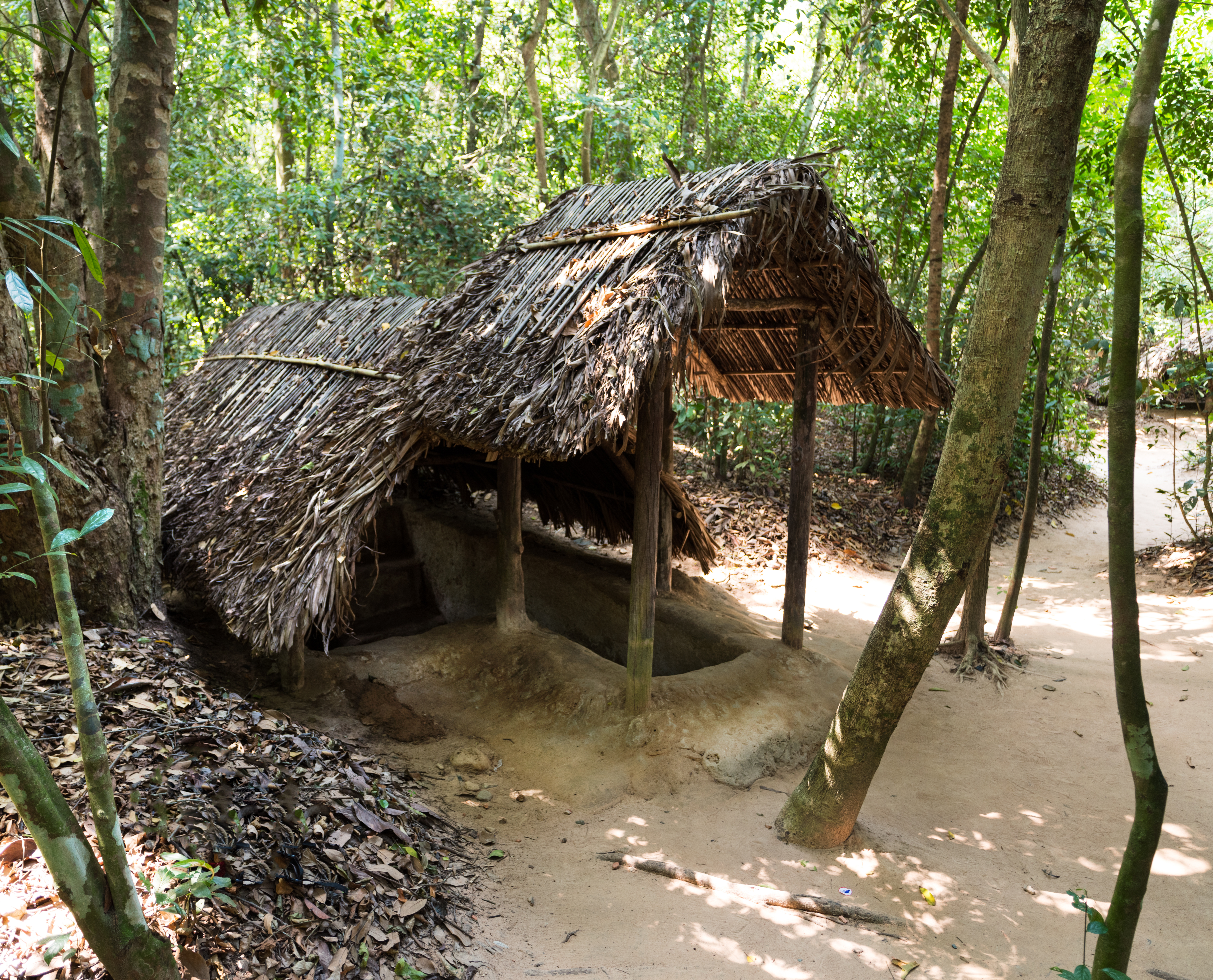 Traditionel indgang til Cu Chi tunnelerne i Vietnam med stråtag i jungle