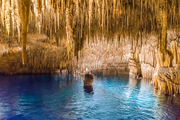 Magisk blå underjordisk sø i Dragegrotten (Cuevas del Drach) med gyldne drypsten på Mallorca, Spanien