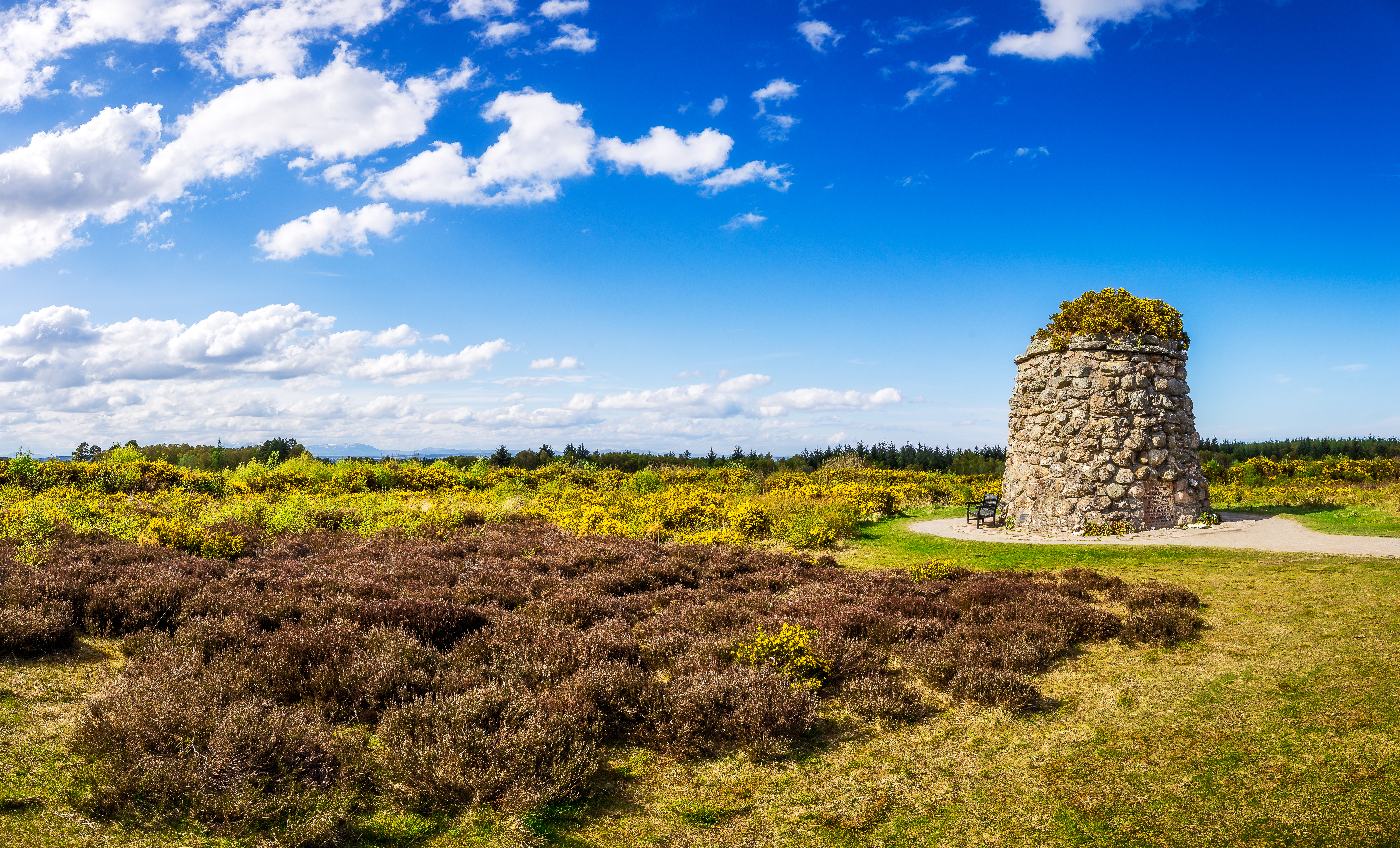 Historisk stenmindesmærke på Culloden Slagmark i de skotske Højlande under blå himmel