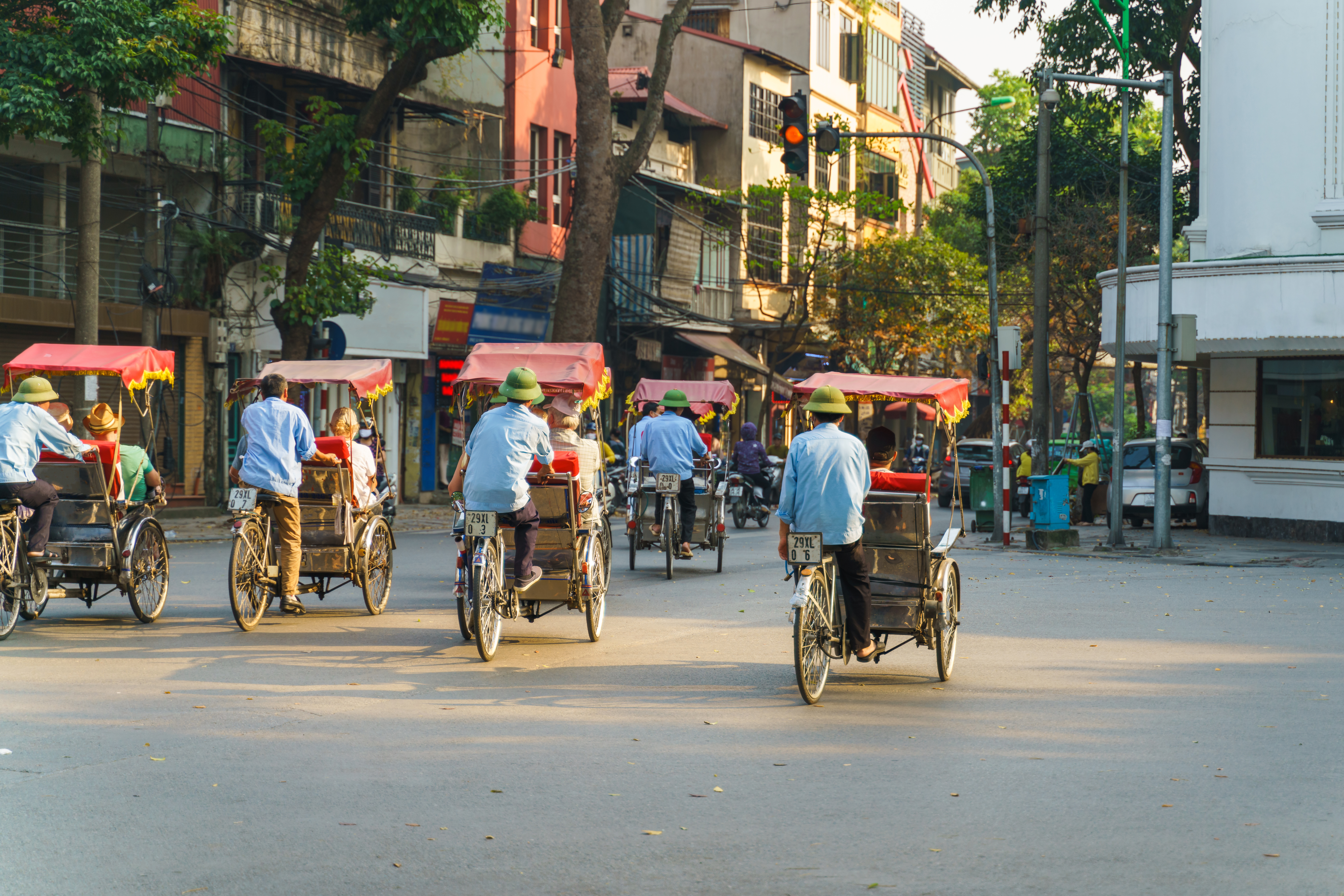 Traditionelle cyclo-chauffører kører turister gennem Hanois travle gamle kvarter i Vietnam