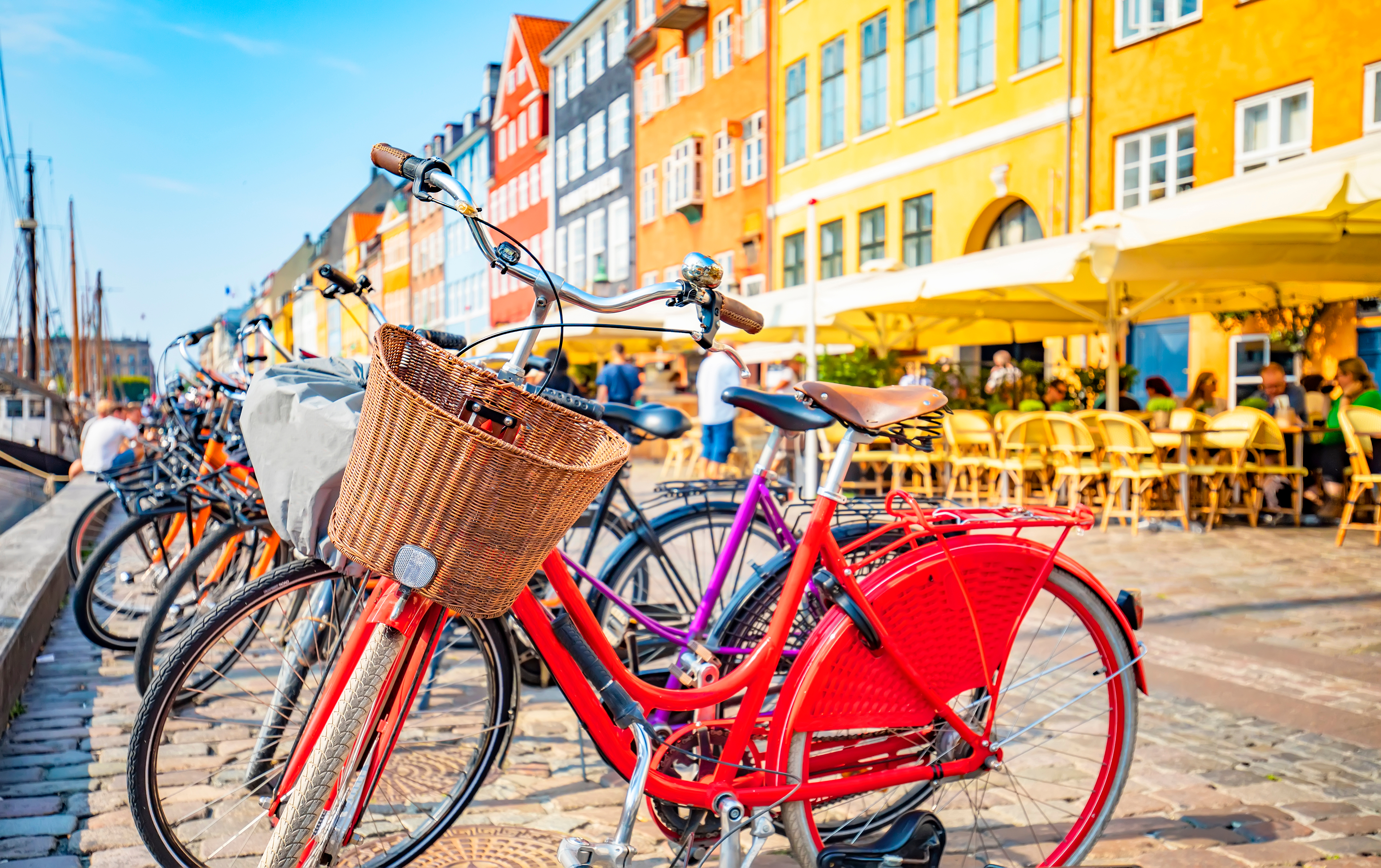 Farverige cykler parkeret langs Nyhavn kanal med traditionelle danske bygninger i København