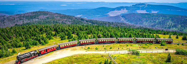 Damptogsrejse gennem smukt bjerglandskab med grønne skove og bakker