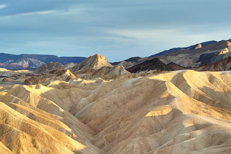 Gylden solnedgang over Death Valley ørkenbjerge og badlands i Californien