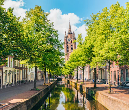 Historisk kanal med kirketårn i Delft Holland på solrig forårsdag