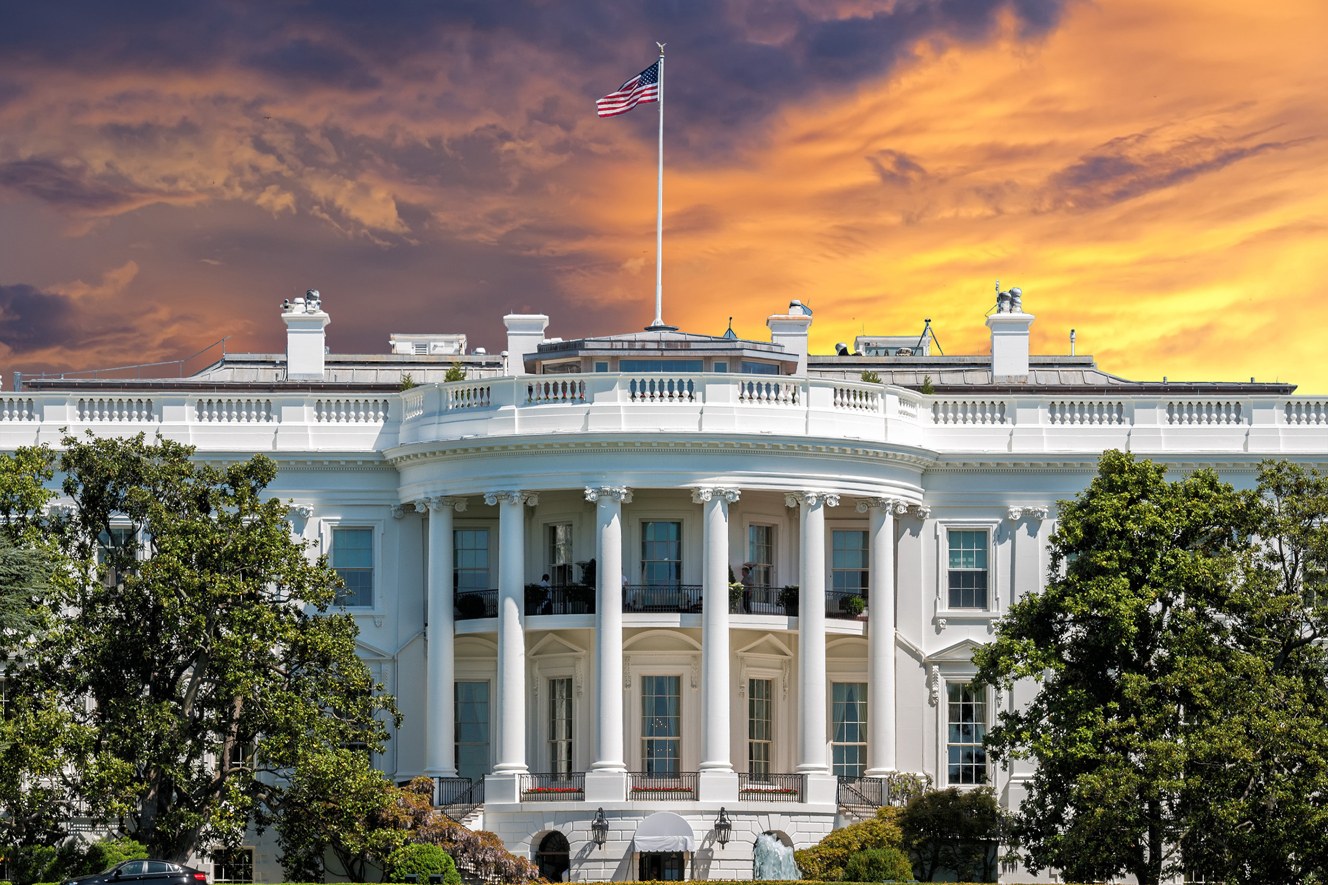 Det Hvide Hus i Washington DC med amerikansk flag ved solnedgang