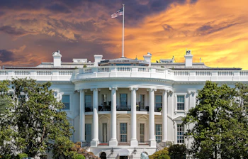 Det Hvide Hus i Washington DC med amerikansk flag ved solnedgang