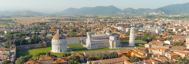 Luftfoto af det skæve tårn og katedralen i Pisa set fra oven i aftenlys på Piazza dei Miracoli, et must-see i Toscana, Italien