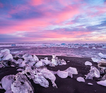 Fantastisk solnedgang over isblokke på Diamond Strand i Island.