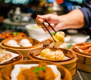 Traditionel dim sum med dumplings i bambuskurve på restaurant i Hong Kong