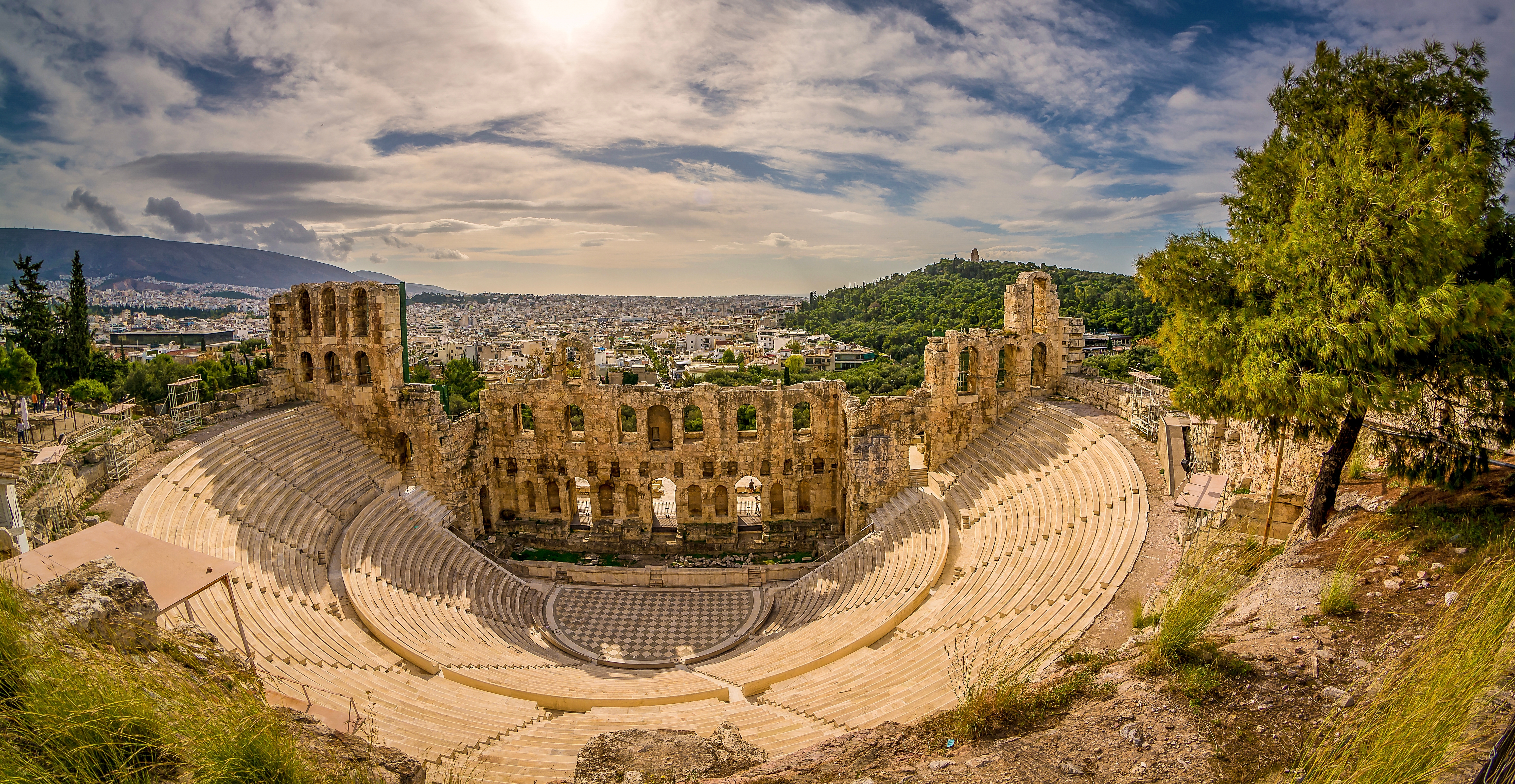 Det antikke Dionysus-teater i forgrunden med den berømte Akropolis-høj og Parthenon-templet i baggrunden, to ikoniske seværdigheder i Athens historiske centrum