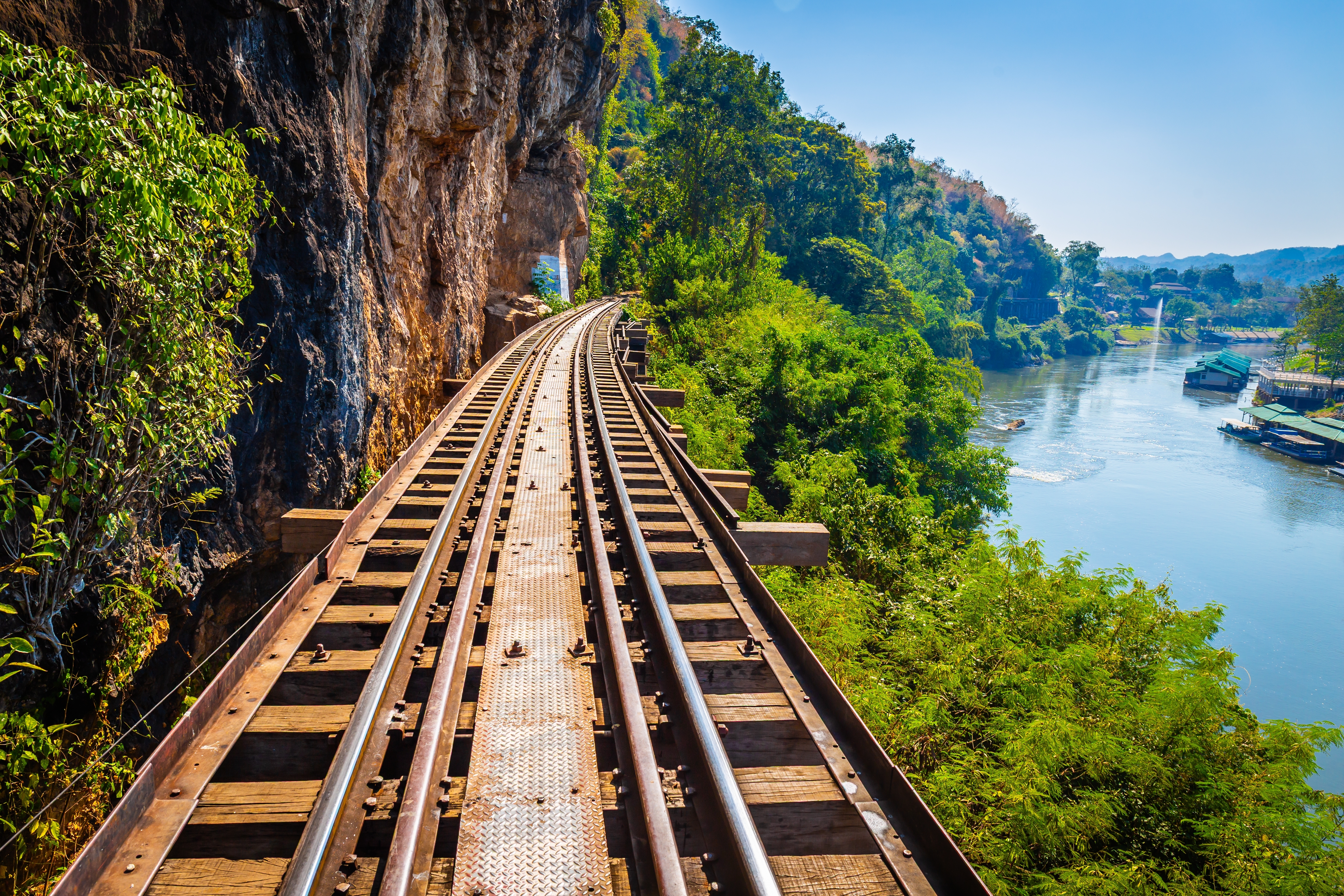 Dødsjernbanen slynger sig langs klippen over Kwai-floden i Kanchanaburi, Thailand, omgivet af frodig jungle og smukke bjerglandskaber