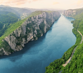 Betagende luftfoto af Donau-floden der snor sig gennem Iron Gate-kløften i Djerdap Nationalpark i Serbien med dramatiske klipper og frodig natur