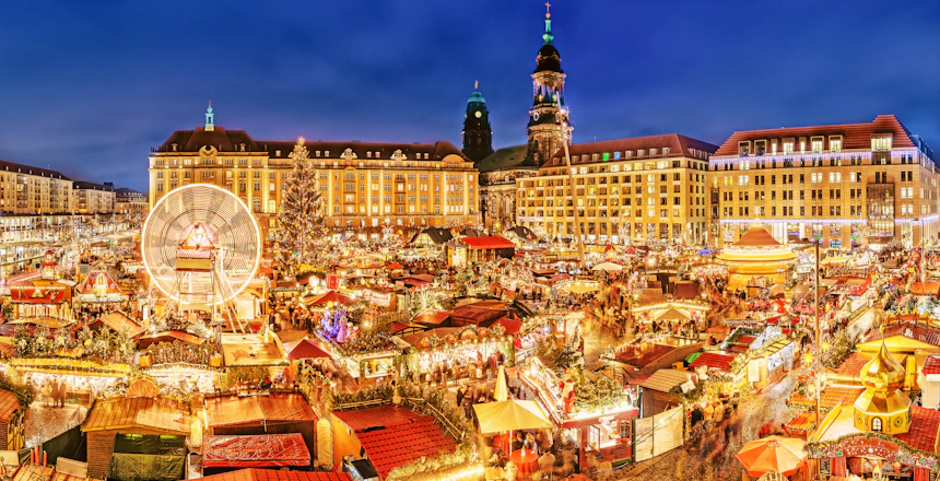 Dresden julemarked om natten med oplyste bygninger og traditionelle træboder i Tyskland