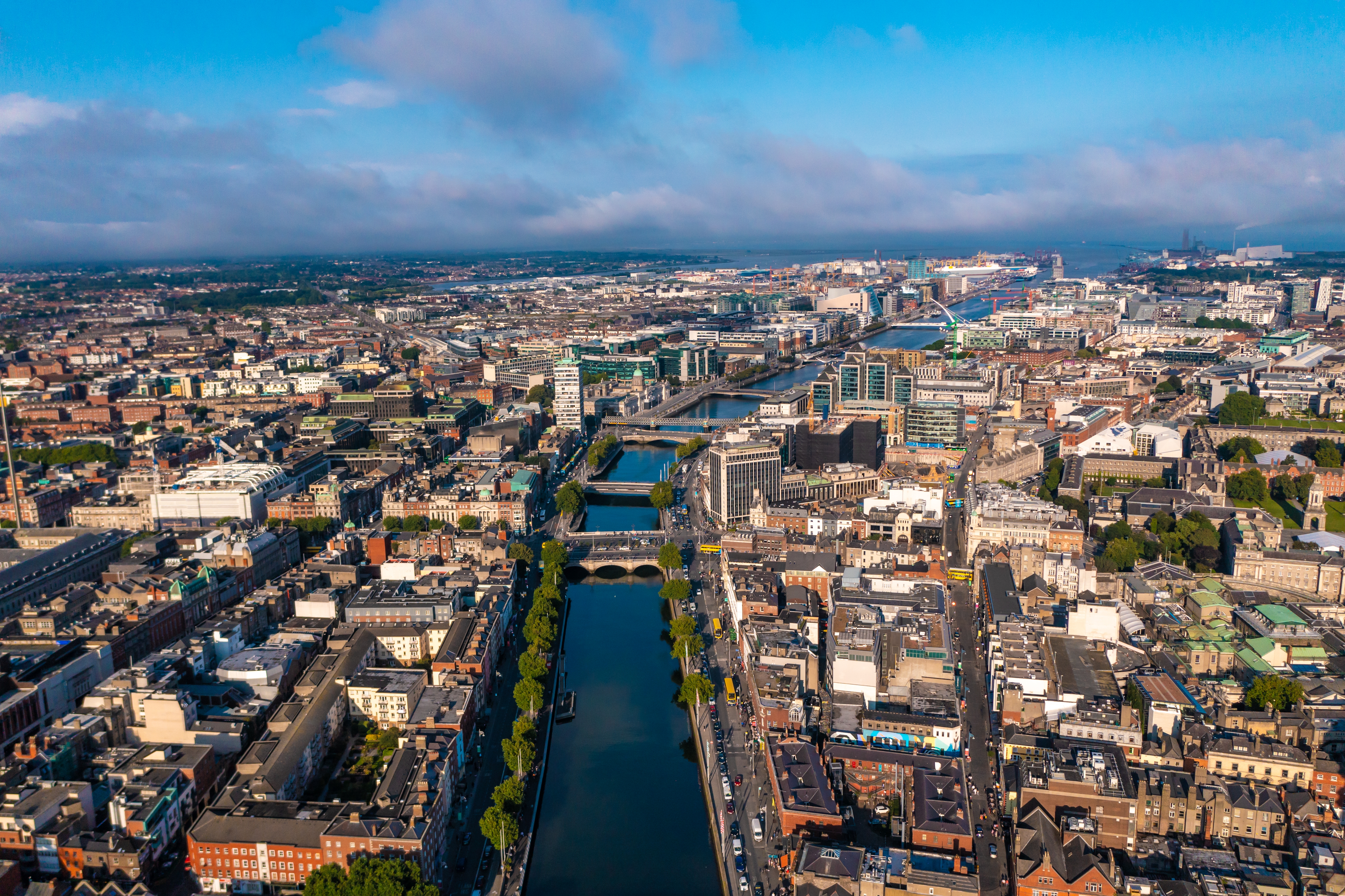 Panoramaudsigt over Dublins skyline med floden Liffey, historiske broer og byarkitektur under skyet himmel