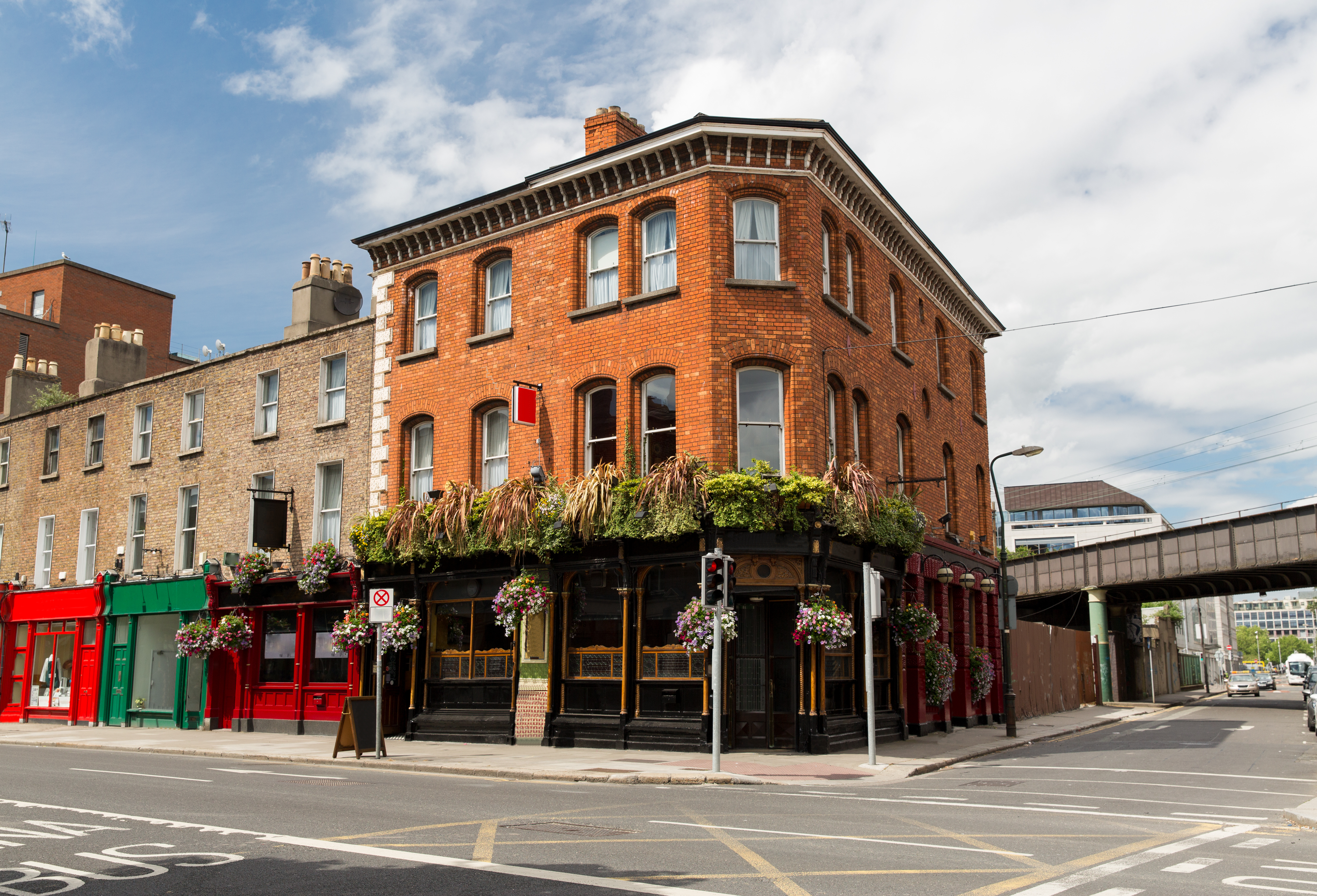 Traditionel irsk pub med røde mursten og blomsterkurve på gadehjørne i Dublin, Irland