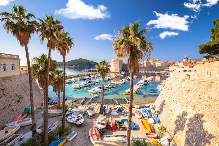 Historiske Dubrovnik gammel havn med stenborger og både i krystalklart tyrkisblåt vand