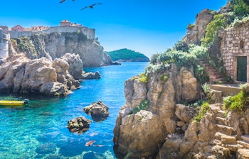 Idyllisk marmor-bugt i Dubrovniks gamle bydel med krystalklart turkisblåt vand omgivet af historiske bymure, kendt som Game of Thrones optagelsessted i Kroatien