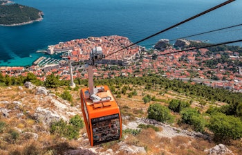 Orange svævebane over Dubrovniks middelalderlige gamle bydel med panoramaudsigt over terrakottatagene og det azurblå Adriaterhav på en solrig sommerdag i Kroatien