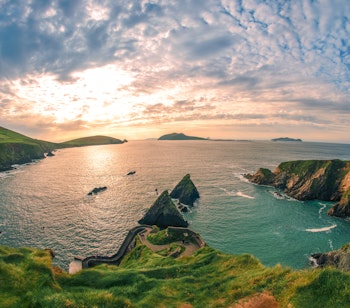 Betagende udsigt over Dunquin Pier på Dingle-halvøen i Kerry, Irland med dramatiske klipper og Atlanterhavet