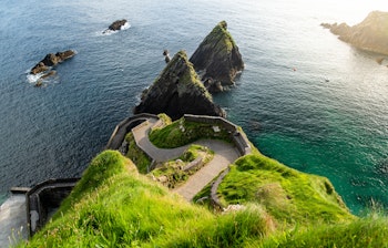 Den ikoniske snoede sti ved Dunquin Pier, kendt som Irlands Fårevej, der slynger sig ned ad de grønne klipper til Atlanterhavet på Dingle-halvøen