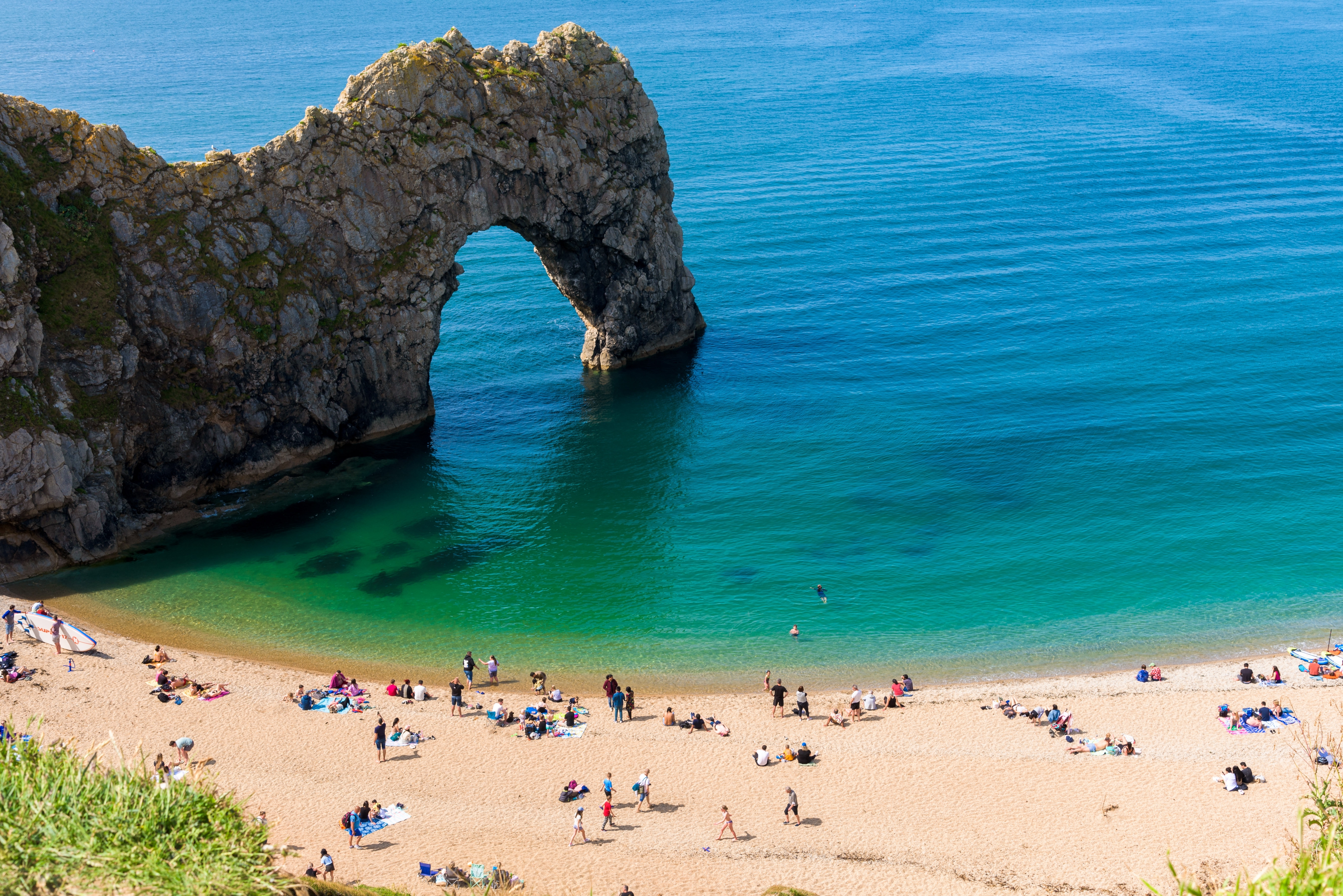 Den imponerende Durdle Door naturlige stenbue med krystalklart vand og sandstrand ved Jurassic Coast i Dorset, Sydengland