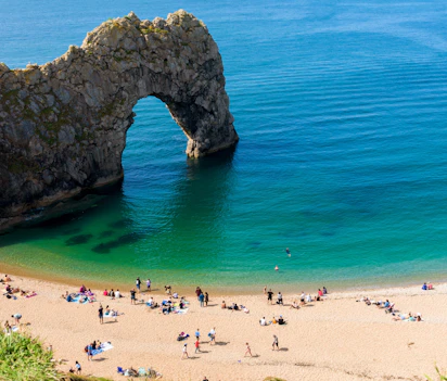 Den imponerende Durdle Door naturlige stenbue med krystalklart vand og sandstrand ved Jurassic Coast i Dorset, Sydengland