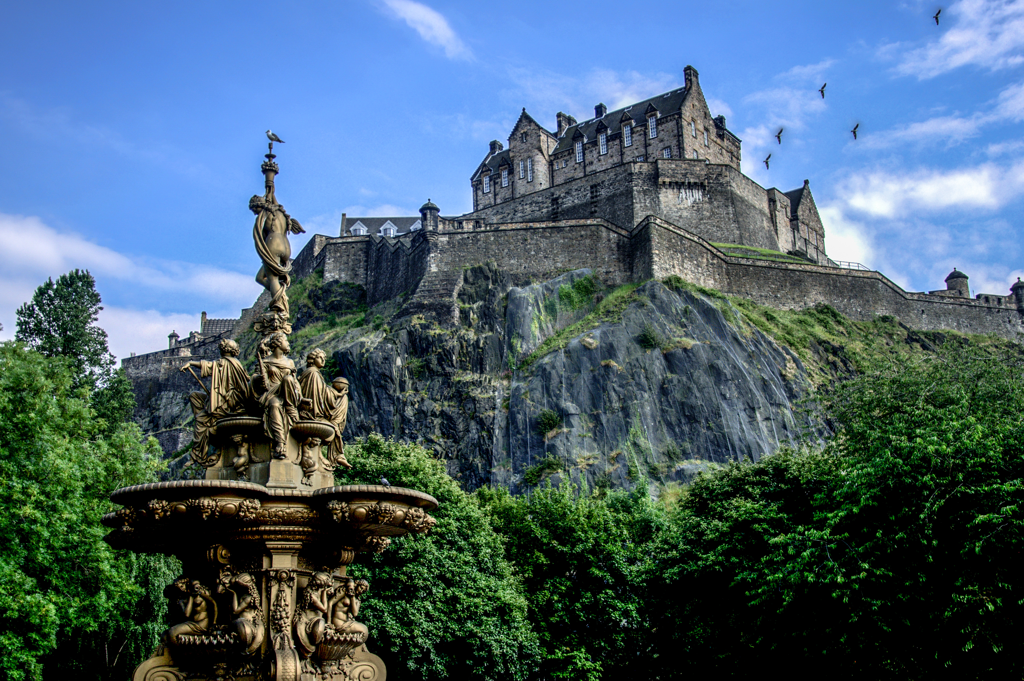 Edinburgh Castle på vulkansk klippe med smuk fontæne i Princes Street Gardens, Skotland