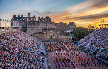 Imponerende aftenfremvisning af Edinburgh Royal Military Tattoo med militærbands foran det historiske Edinburgh slot i Skotland